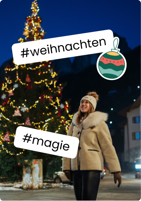 Frau in Winterjacke lächelnd vor beleuchtetem Weihnachtsbaum, Aufkleber #weihnachten und #magie
