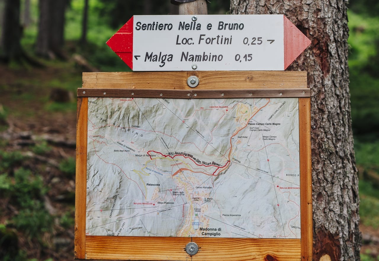 Cartello Sentiero Nella e Bruno con direzioni e mappa su albero