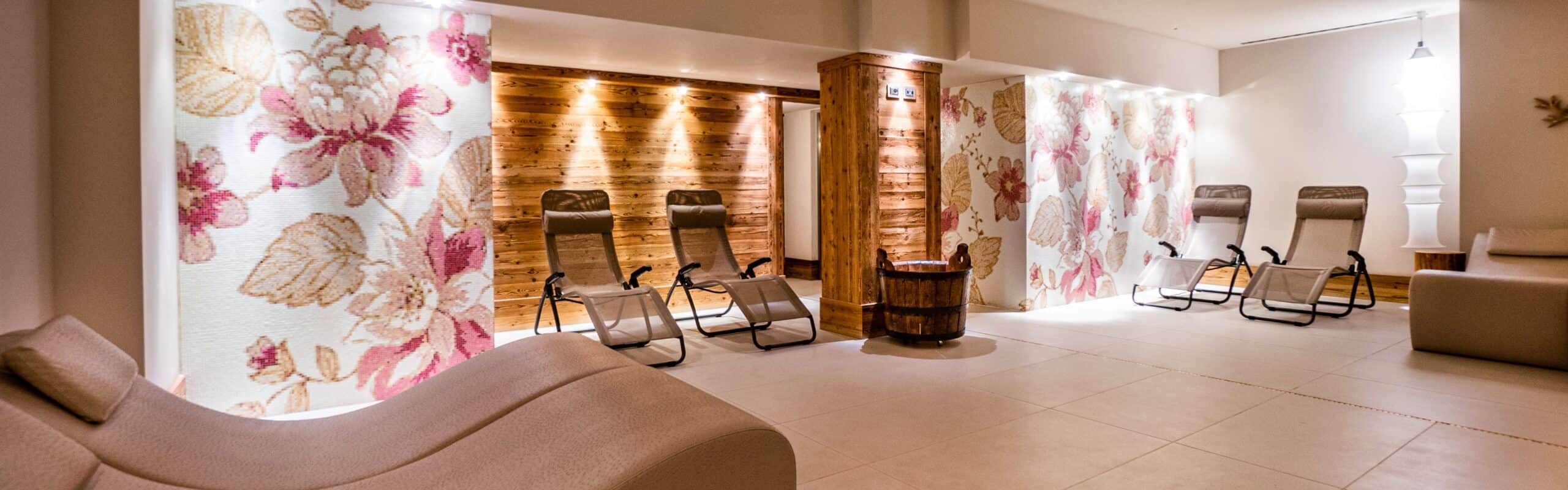 Sala relax con poltrone reclinabili, pareti in legno e mosaico floreale, pavimento piastrellato