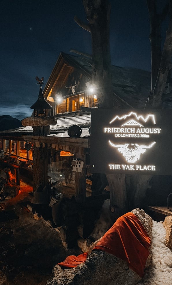 Chalet in legno notturno con insegna illuminata FRIEDRICH AUGUST DOLOMITES 2300m THE YAK PLACE