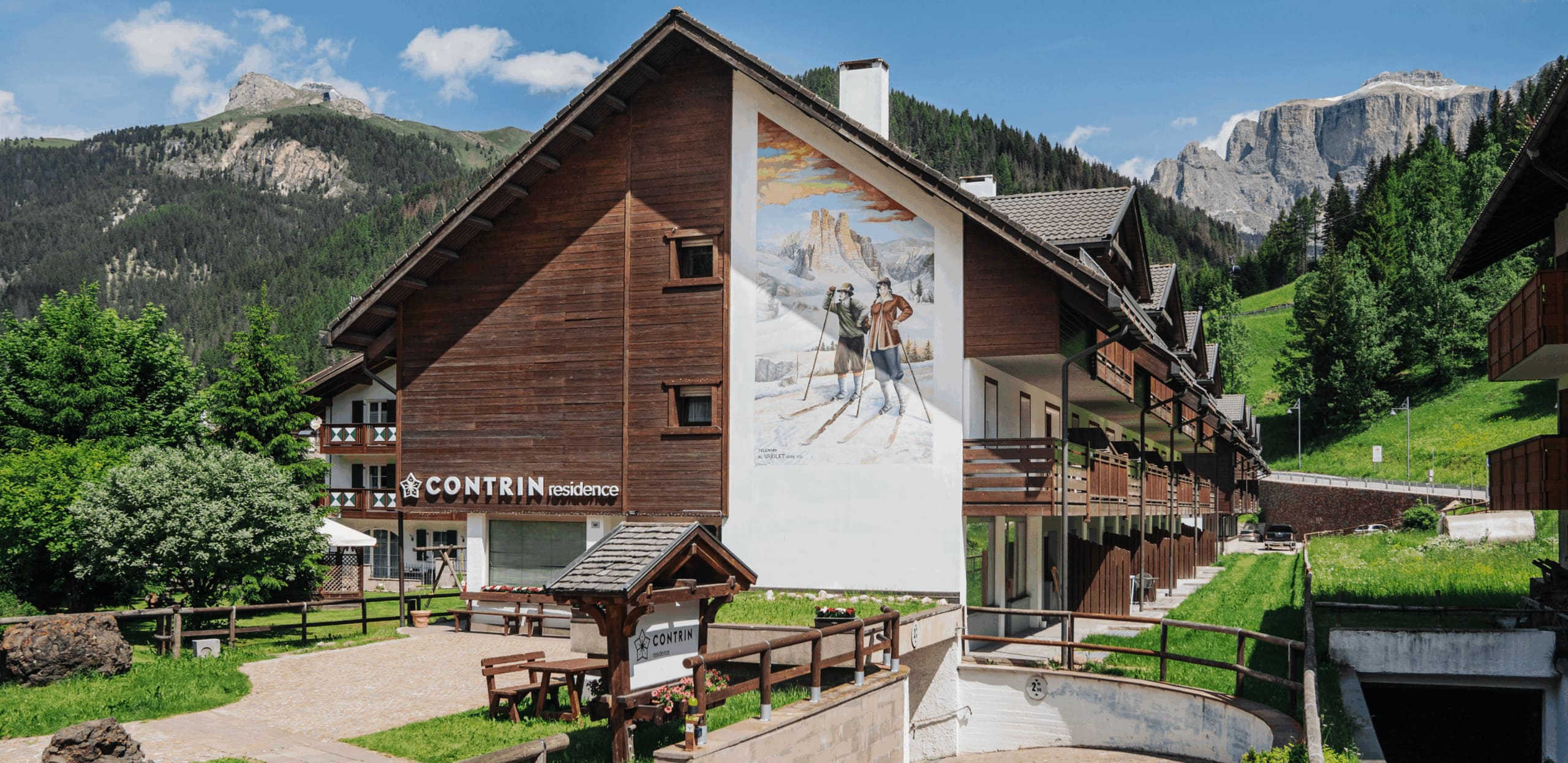 Edificio Contrin Residence con murale raffigurante sciatori e montagne alpine sullo sfondo