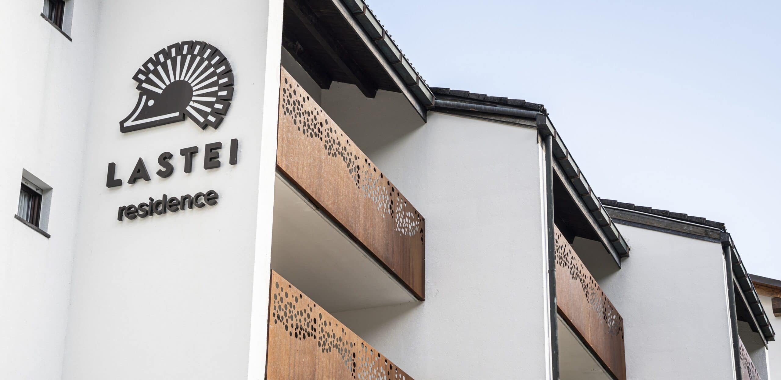 Edificio Lastei Residence, balconi in metallo traforato e logo LASTEI Residence sulla facciata