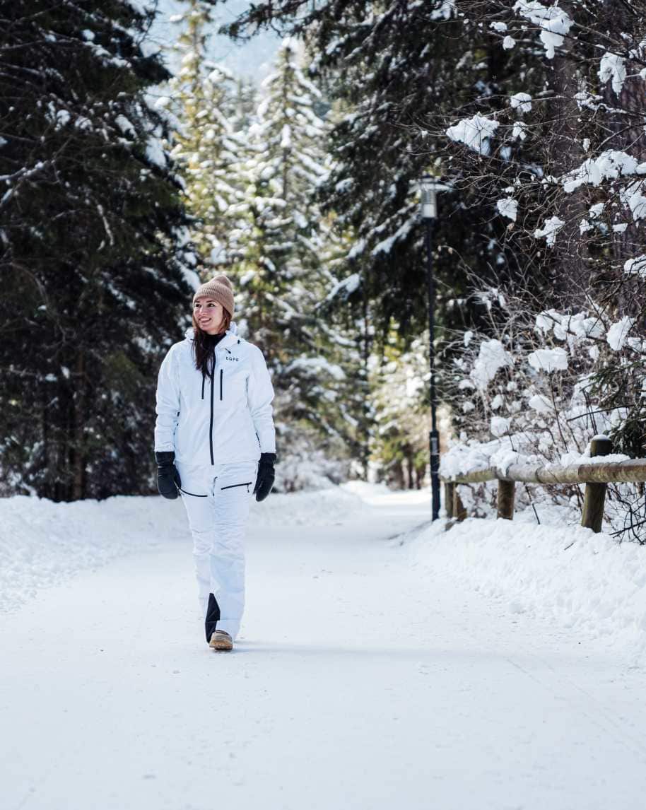 Ragazza che passeggia nella neve tra gli alberi innevati su strada forestale nei pressi del Garni Aritz B&B di Campitello di Fassa